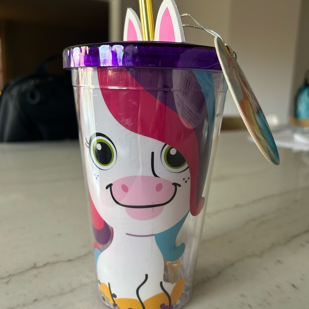 Unicorn Tumbler filled with cherry bath bombs and a bath pouf